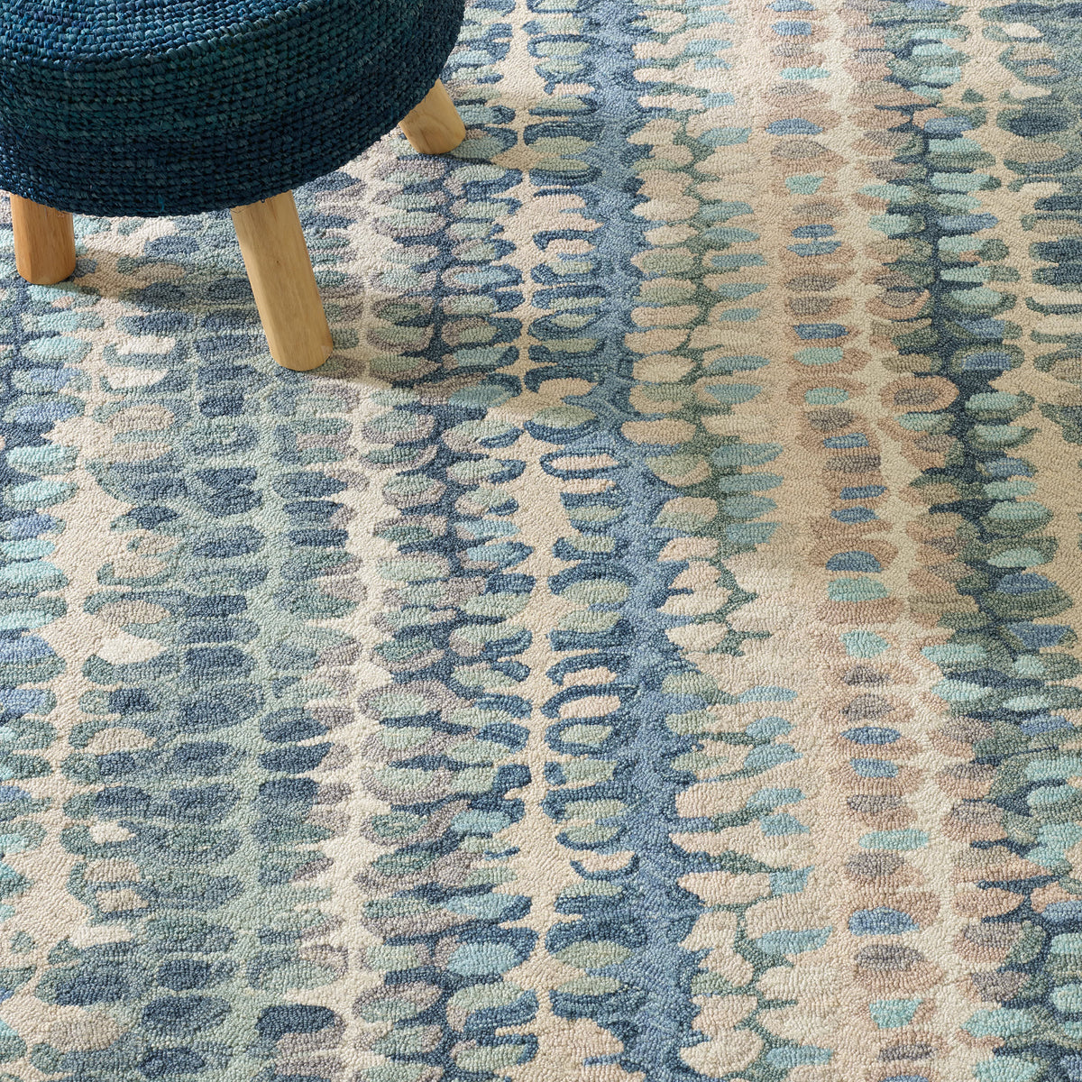 Dash & Albert Paint Chip Hand Micro Hooked Wool Rug in Blue, close-up with a stool