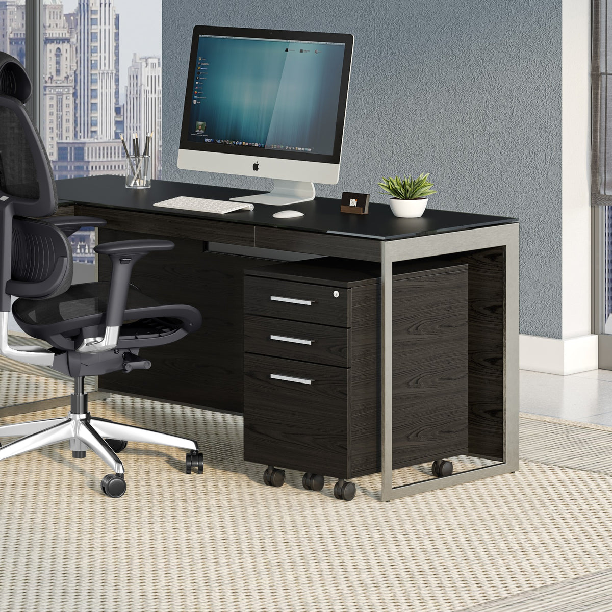 BDi Sequel 20 6107 Mobile File Cabinet in Charcoal Stained Ash, under an L-shaped desk, in an office