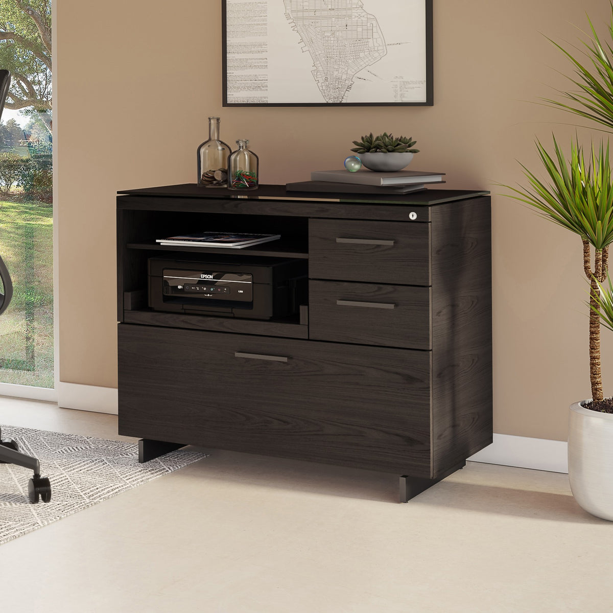 BDi Sequel 20 6117 Multi Function Cabinet in Charcoal Stained Ash, with a black base, beside a desk, in a home office