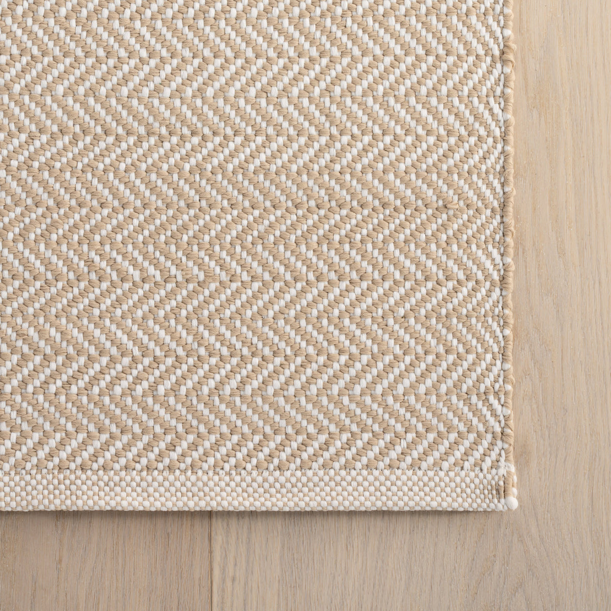 Dash & Albert Herringbone Handwoven Indoor/Outdoor Rug in Linen / White, corner detail