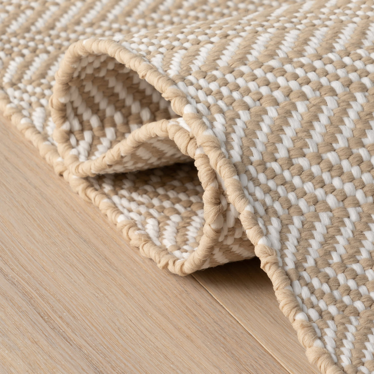 Dash & Albert Herringbone Handwoven Indoor/Outdoor Rug in Linen / White, folded