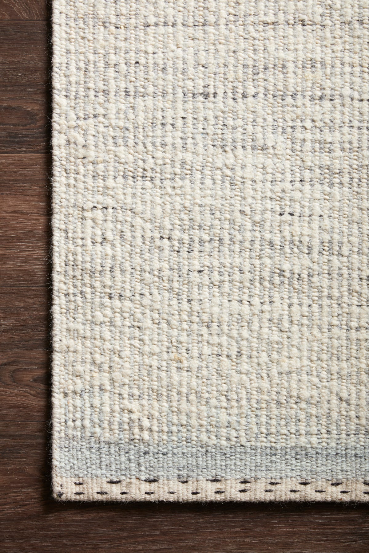 Loloi Sloane Rug 01 in Smoke, corner on a wood floor