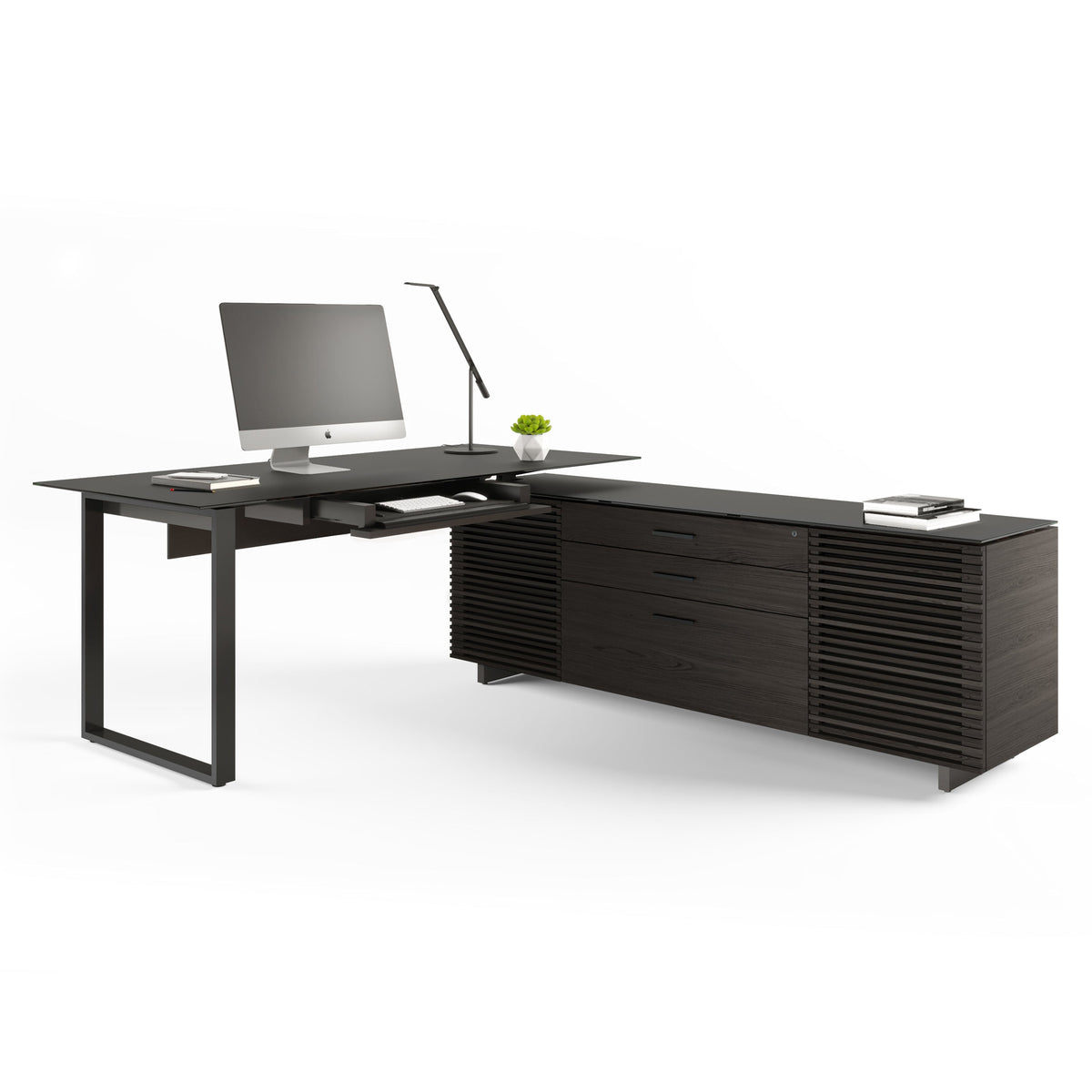 BDi Corridor 6531 L-Shaped Office Desk in Charcoal Stained Ash, angled view with a computer and the keyboard tray out, on white