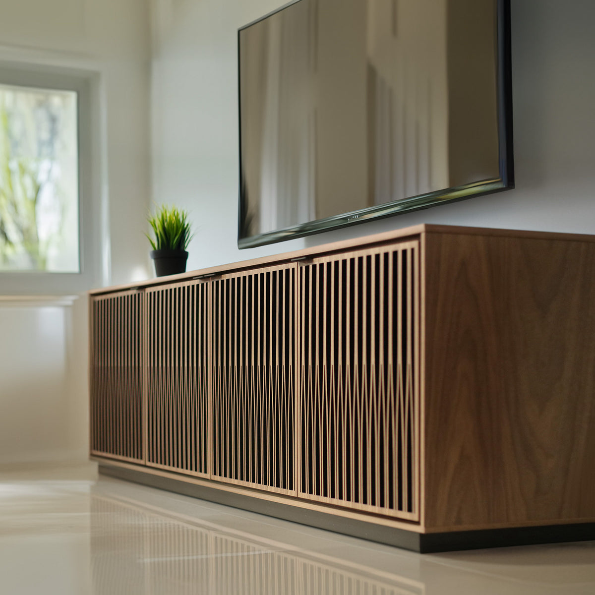 BDi Elements 8703 Media + Storage Cabinet in Natural Walnut, low view in a living room under a wall-mounted TV, with Tune door fronts