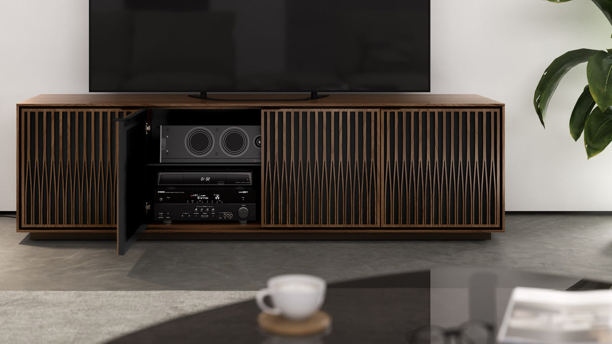 BDi Elements 8703 Media + Storage Cabinet in Natural Walnut, one door open with media equipment, in a living room, with Tune door fronts