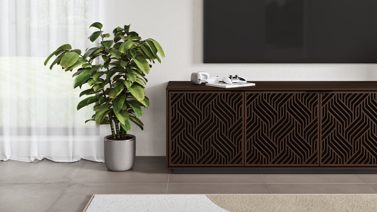 BDi Elements 8703 Media + Storage Cabinet in Toasted Oak, under a TV, beside a plant, with Weave door fronts