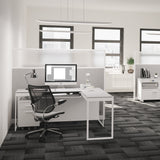 BDi Centro 6402 Desk Extension in Satin White on Oak with Grey Glass, joined to a desk, in an open office