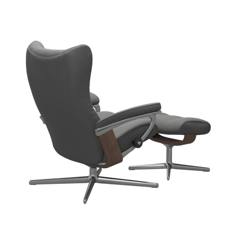 Stressless Wing Recliner Cross Base in Paloma Neutral Grey, three-quarter back view reclined with footstool, Walnut side panels, size Small