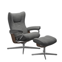 Stressless Wing Recliner Cross Base in Paloma Neutral Grey, three-quarter front view with footstool, Walnut side panels, size Small