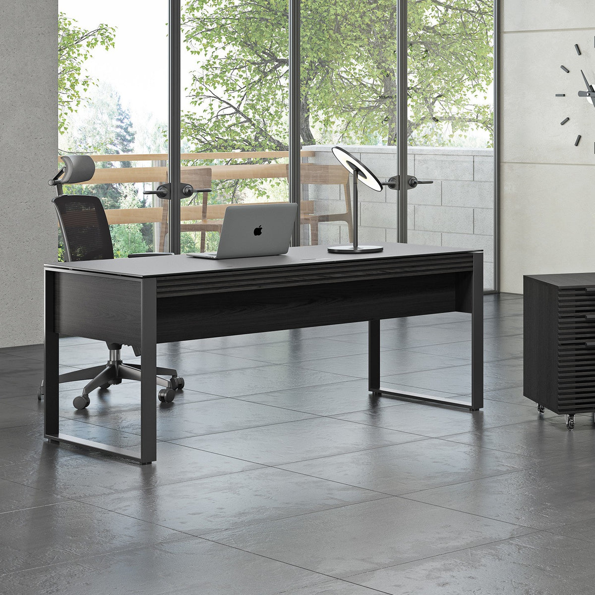 BDi Corridor 6521 Executive Office Desk in Charcoal Stained Ash, seen from the back beside a file pedestal and multi-function cabinet