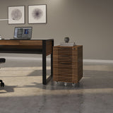 BDi Corridor 6507 Mobile File Cabinet in Natural Walnut, beside a desk in an office