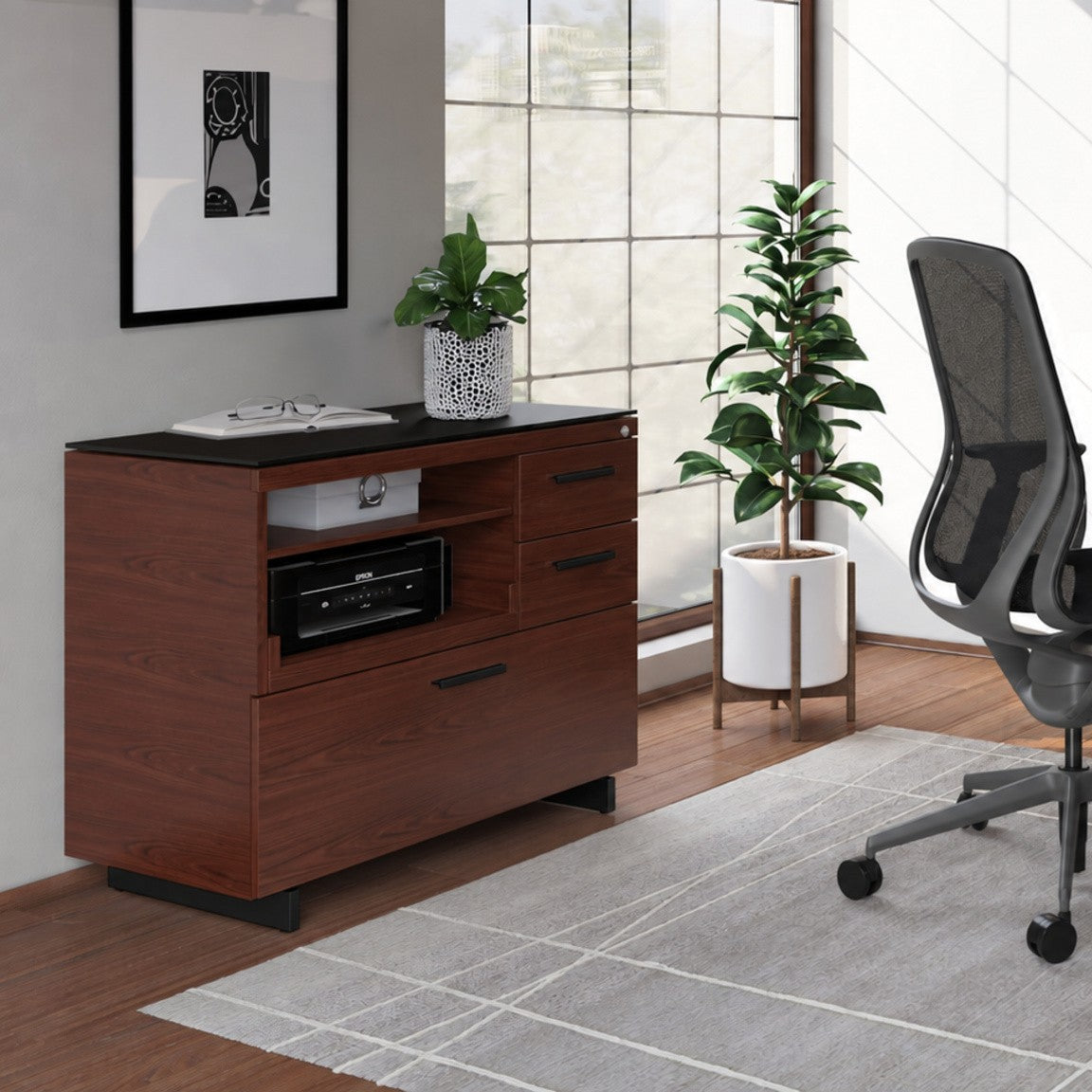 BDi Sequel 20 6117 Multi Function Cabinet in Chocolate Stained Walnut, with a black base, beside a compact desk, in a home office