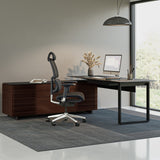BDi Corridor 6531 L-Shaped Office Desk in Chocolate Stained Walnut, in an office beside an open staircase