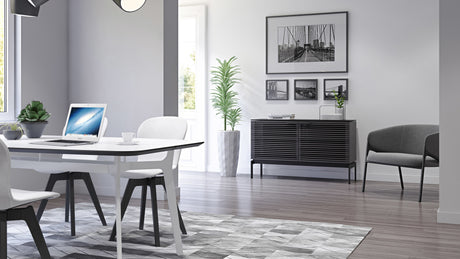BDi Corridor 7128 Compact 2-Door Storage Cabinet in Charcoal Stained Ash, in a dining room, seen past the table