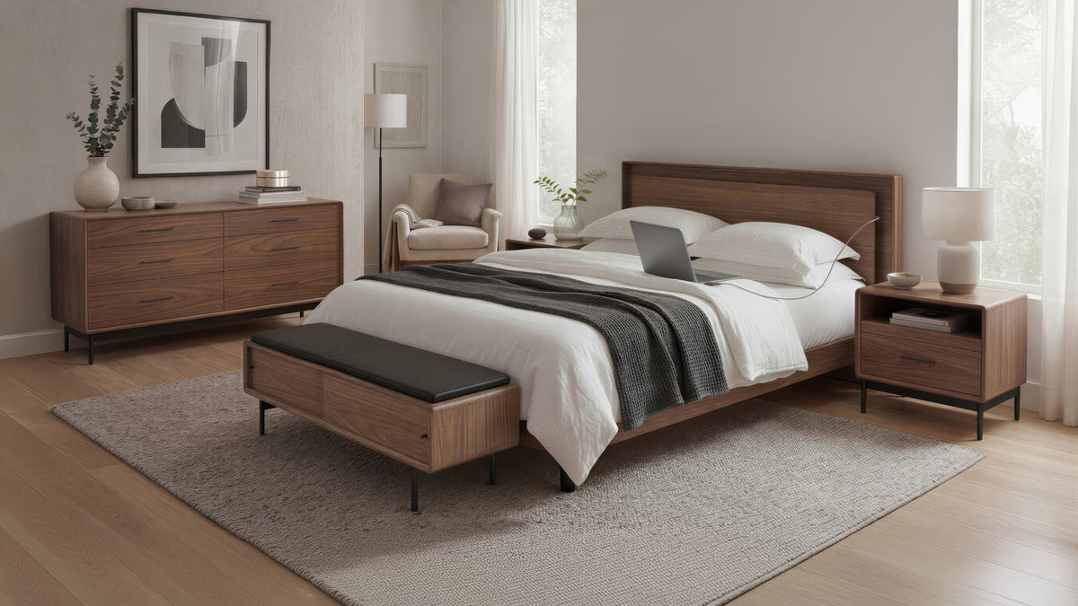 BDi Linq Bench in Pepper | Leather, with a Natural Walnut frame, at the foot of a bed