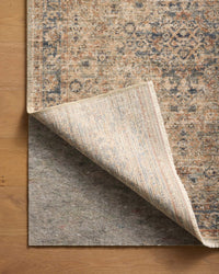 Loloi Loloi- Grip 1/4" Rug Pad in Grey, under a rug, its corner turned back