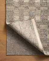 Loloi Loloi- Grip 3/8" Rug Pad in Beige, under a rug, its corner turned back