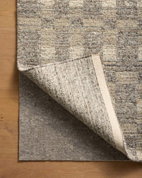 Loloi Loloi- Grip 3/8" Rug Pad in Beige, under a rug, its corner turned back