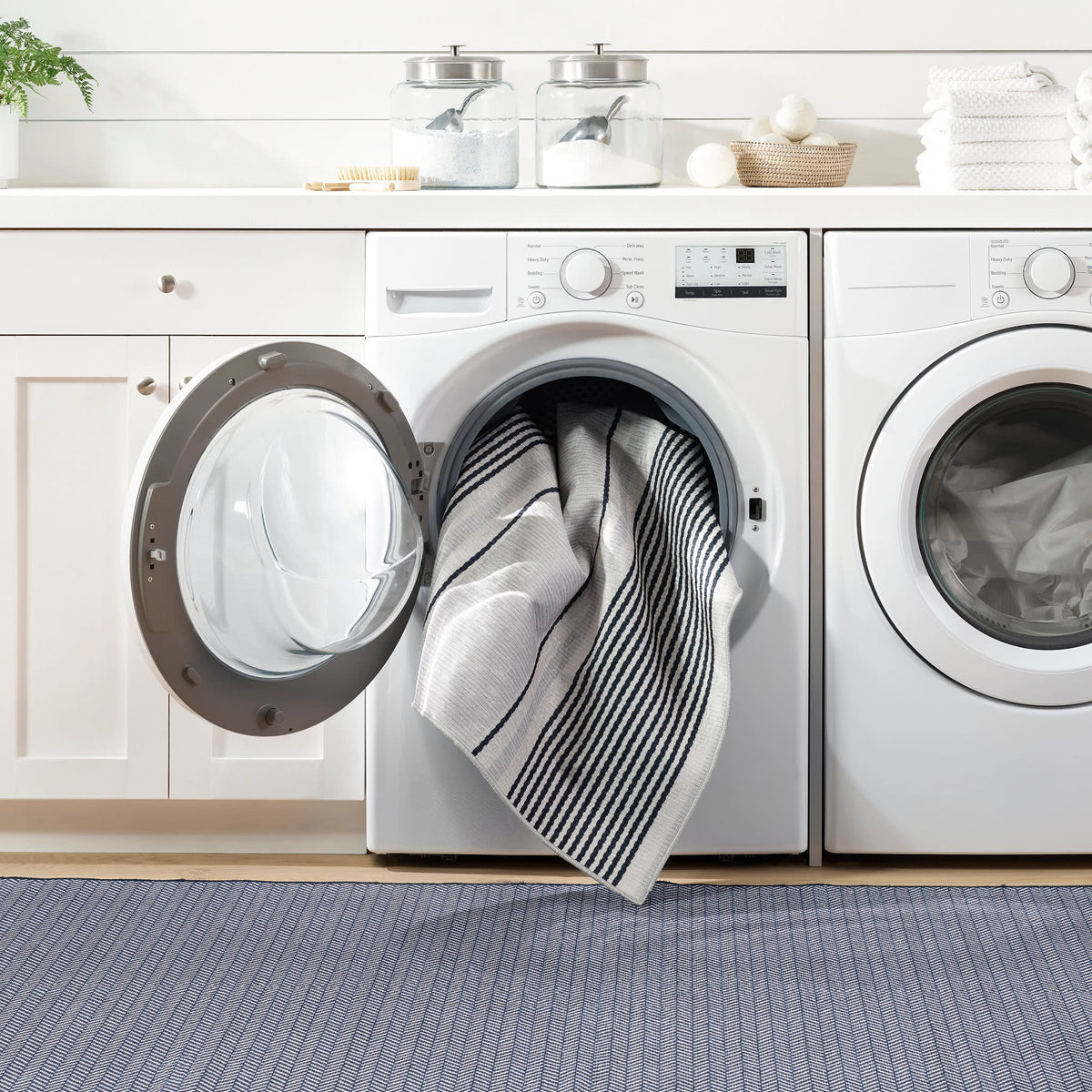 Dash & Albert Herringbone Machine Washable Rug in Navy, laundry room setting