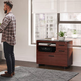 BDi Sequel 20 6117 Multi Function Cabinet in Chocolate Stained Walnut, with a black base, beside a standing desk, in an office
