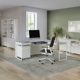 BDi Centro 6402 Desk Extension in Satin White on Oak with Grey Glass, joined to a desk, in an open office