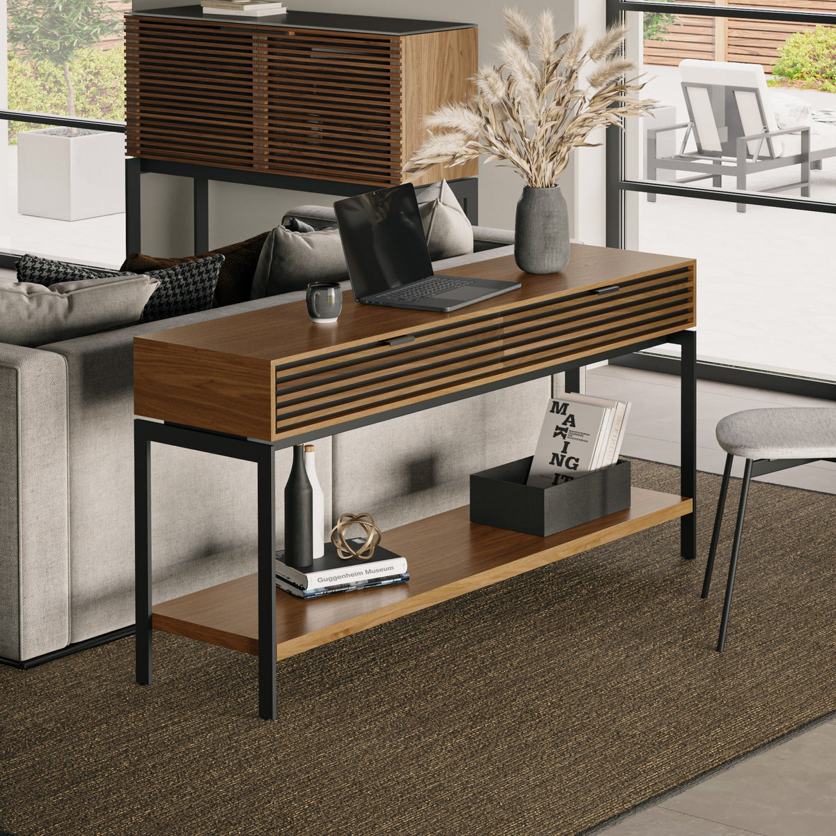 BDi Cora 1173 Console Table in Natural Walnut, behind a sofa, used as a laptop desk