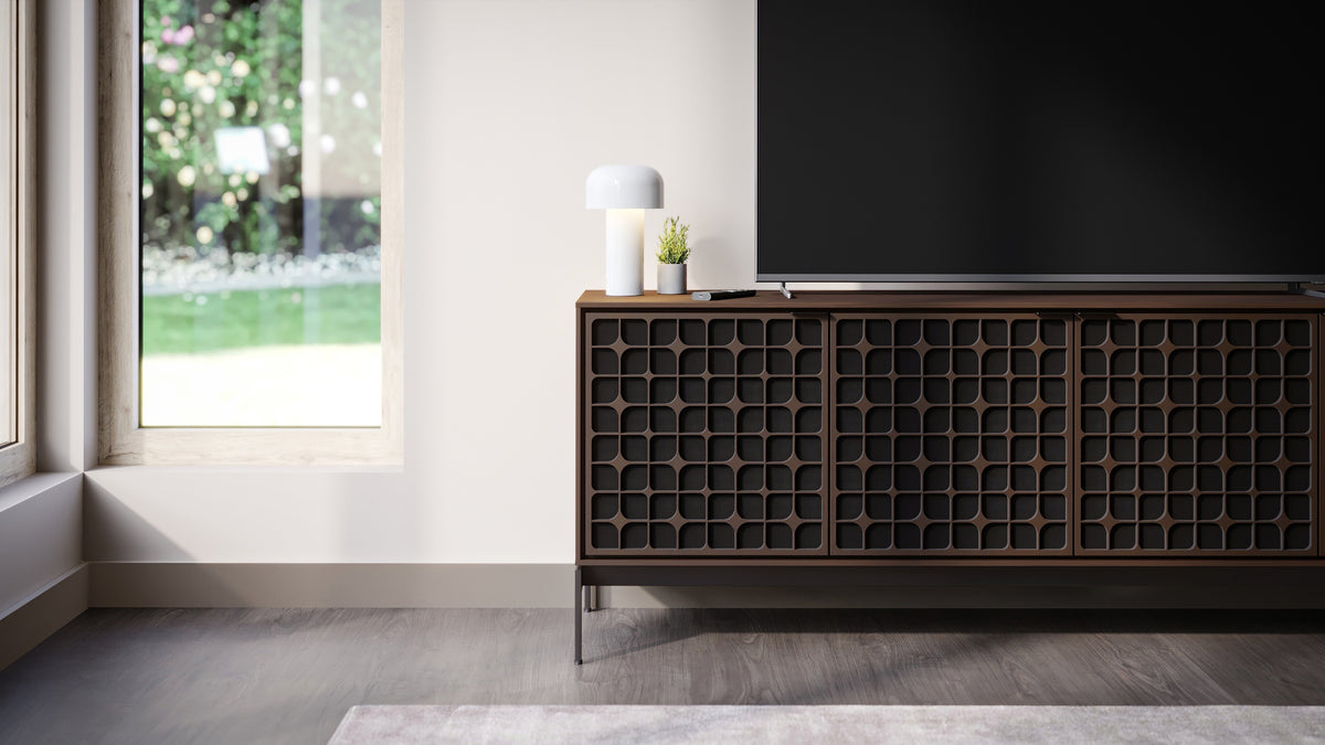 BDi Elements 8709 Media + Storage Console in Toasted Oak, under a TV by a garden window, with Constellation door fronts