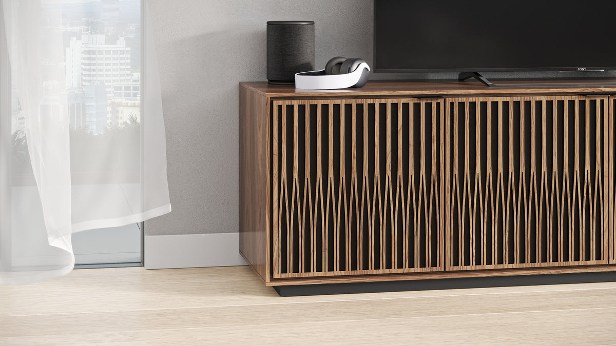 BDi Elements 8703 Media + Storage Cabinet in Natural Walnut, with a TV and a speaker, by a window, with Tune door fronts