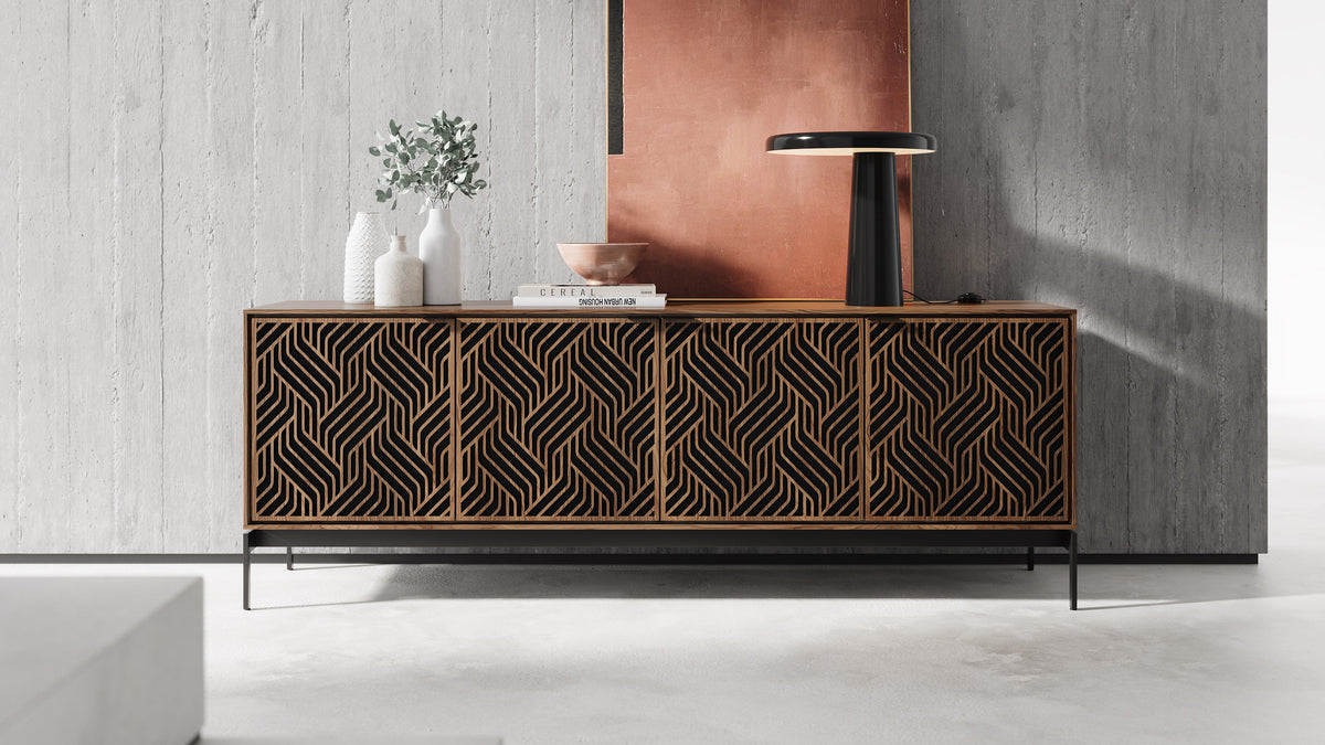 BDi Elements 8709 Media + Storage Console in Natural Walnut, against a concrete wall with a lamp, with Weave door fronts
