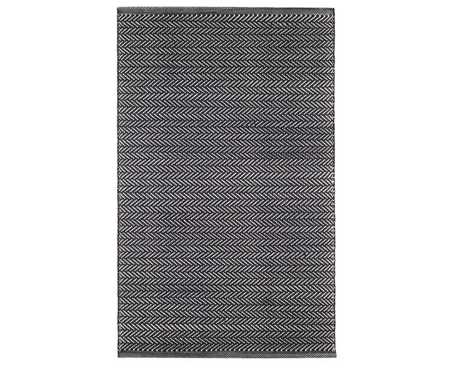 Rug with a herringbone handwoven pattern on a plain background