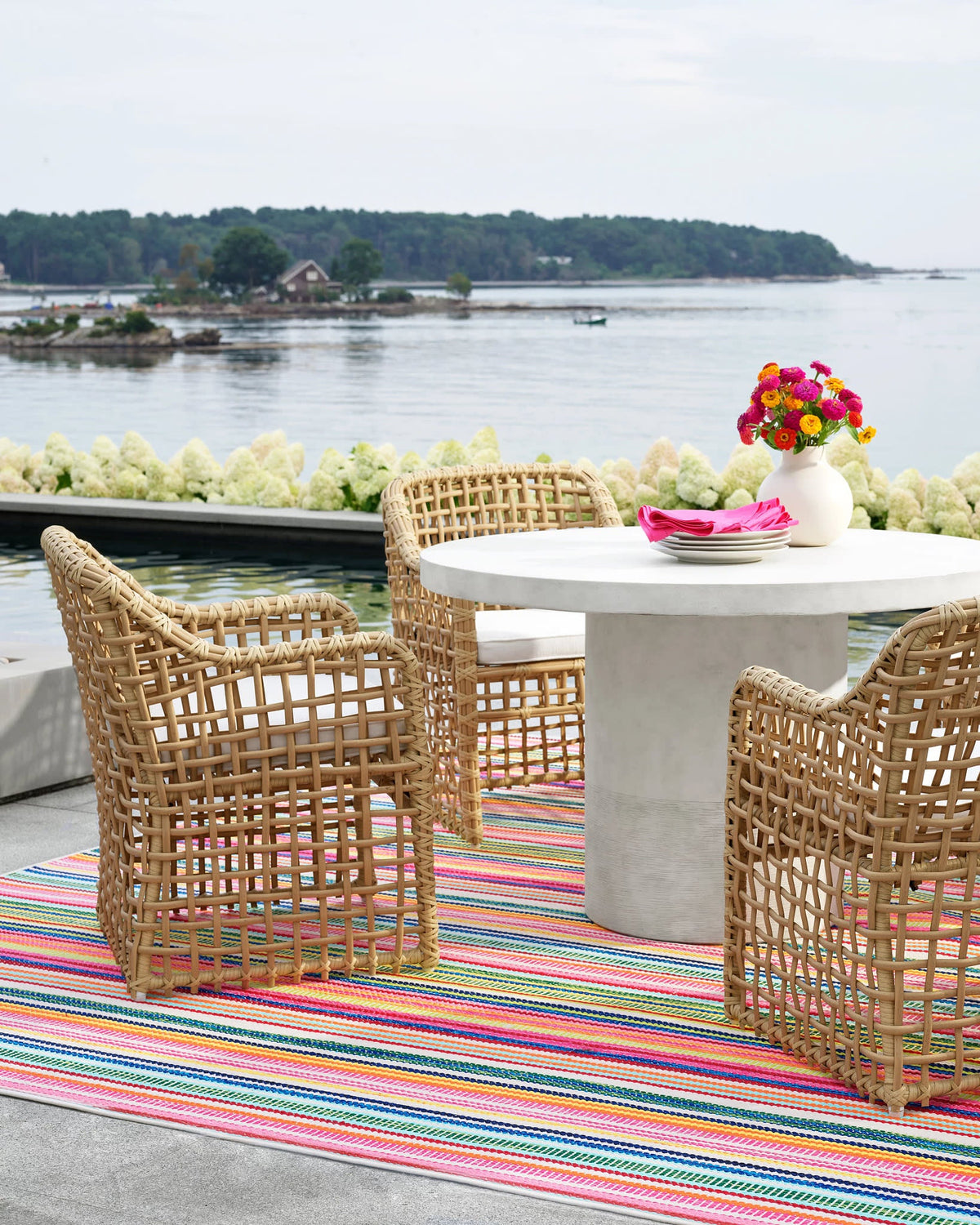 Dash & Albert Bright Stripe Handwoven Indoor/Outdoor Rug in Multi, waterside patio setting
