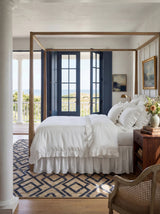 Dash & Albert Marco Jute Soumak Handwoven Rug in Navy, bedroom with a canopy bed