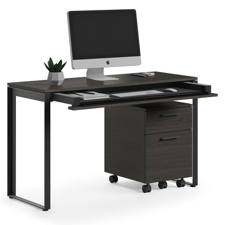 BDi Linea 6222 Console Desk in Charcoal Stained Ash, keyboard drawer open, with a mobile file and monitor, on white
