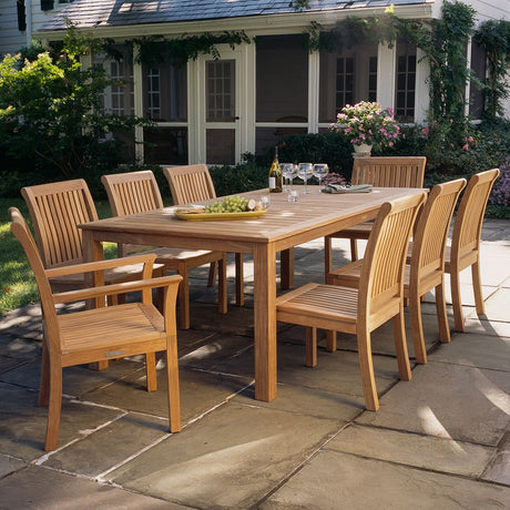Wooden outdoor dining set with table and chairs on a stone patio