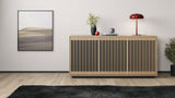 BDi Profile 8477 3-Door Media & Storage Console in Washed Oak, closed, against a wall with a lamp and art