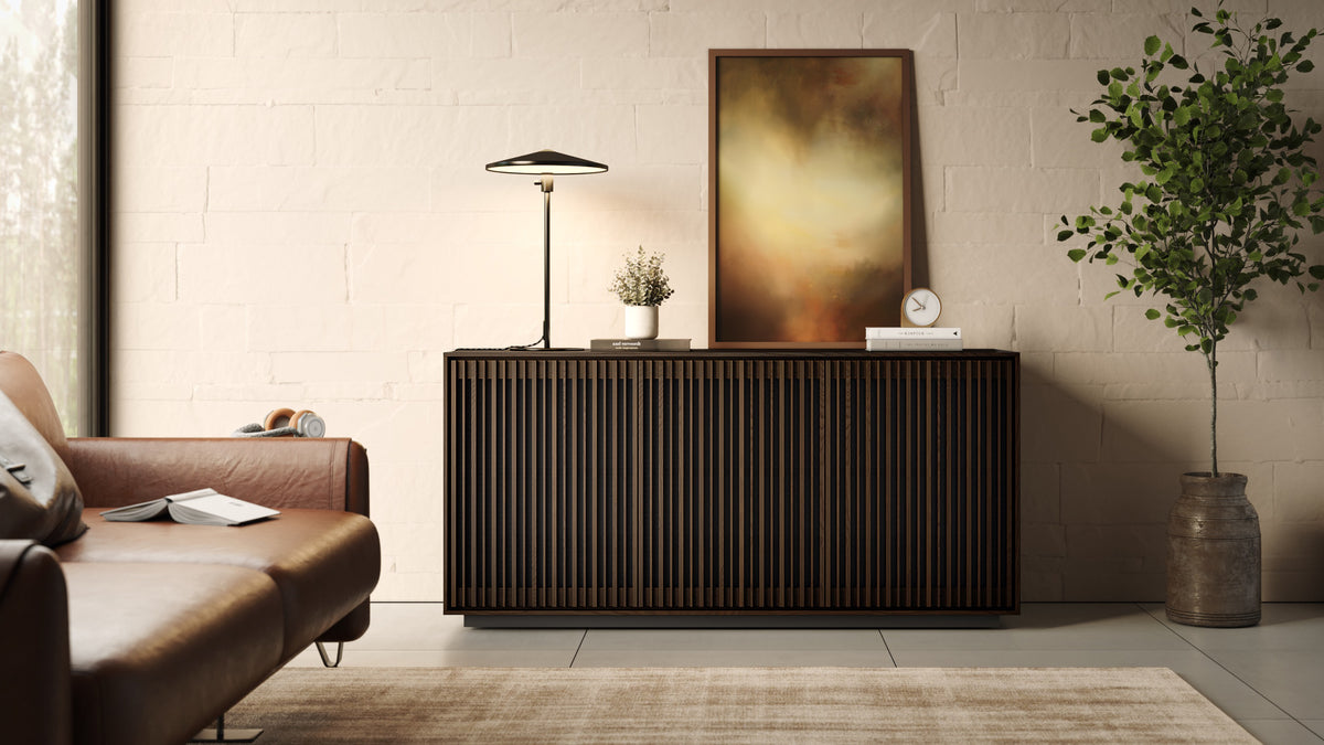 BDi Profile 8477 3-Door Media & Storage Console in Toasted Oak, closed, in a living room under a painting
