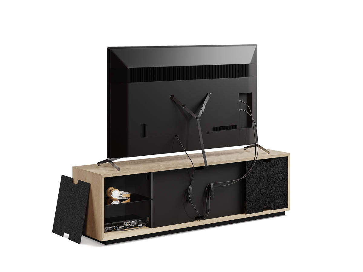 BDi Profile 8479 4-Door Media & Storage Console in Washed Oak, back view with a TV and a rear panel off, on white