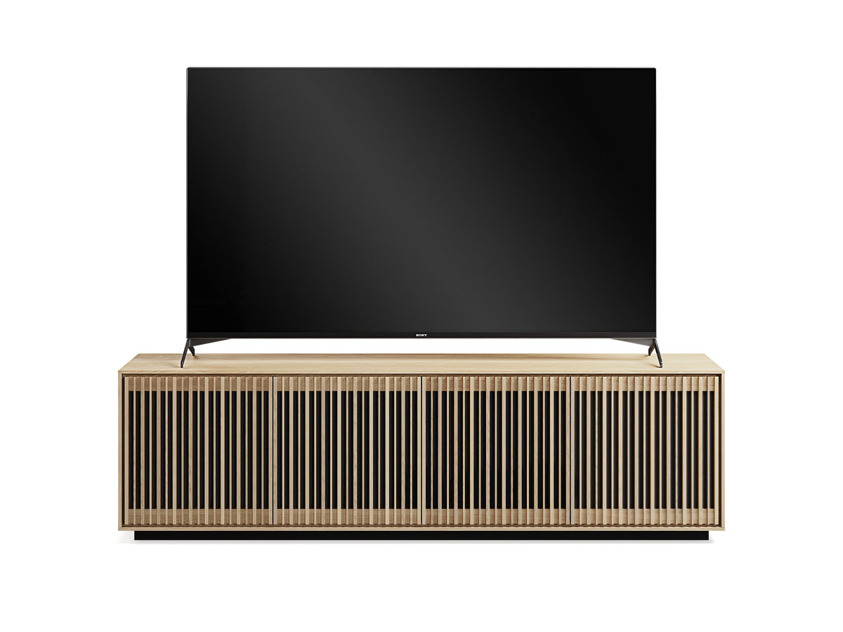 BDi Profile 8479 4-Door Media & Storage Console in Washed Oak, front view with a TV, closed, on white
