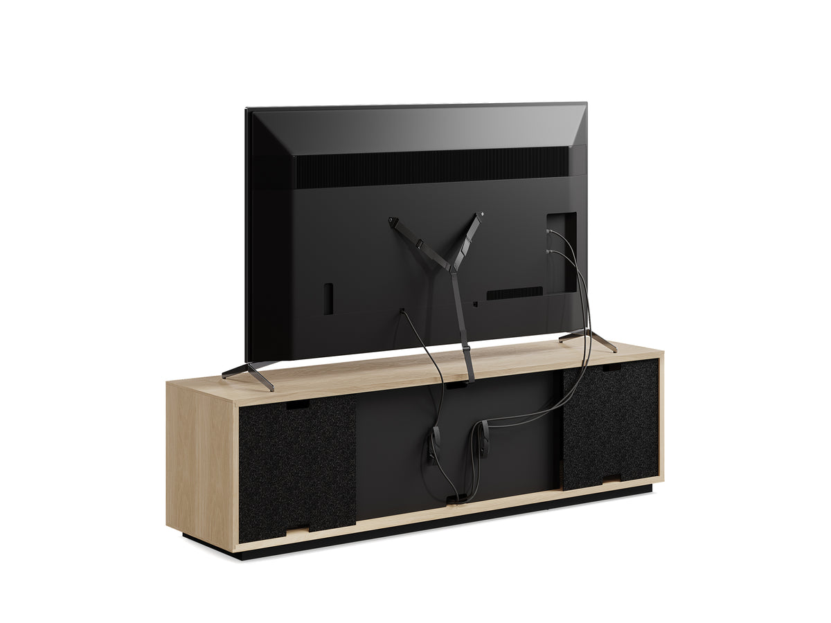 BDi Profile 8479 4-Door Media & Storage Console in Washed Oak, back view with a TV and cables, on white