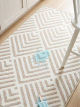 Dash & Albert Cleo Machine Washable Rug in Wilderness Cement, close-up with a stool