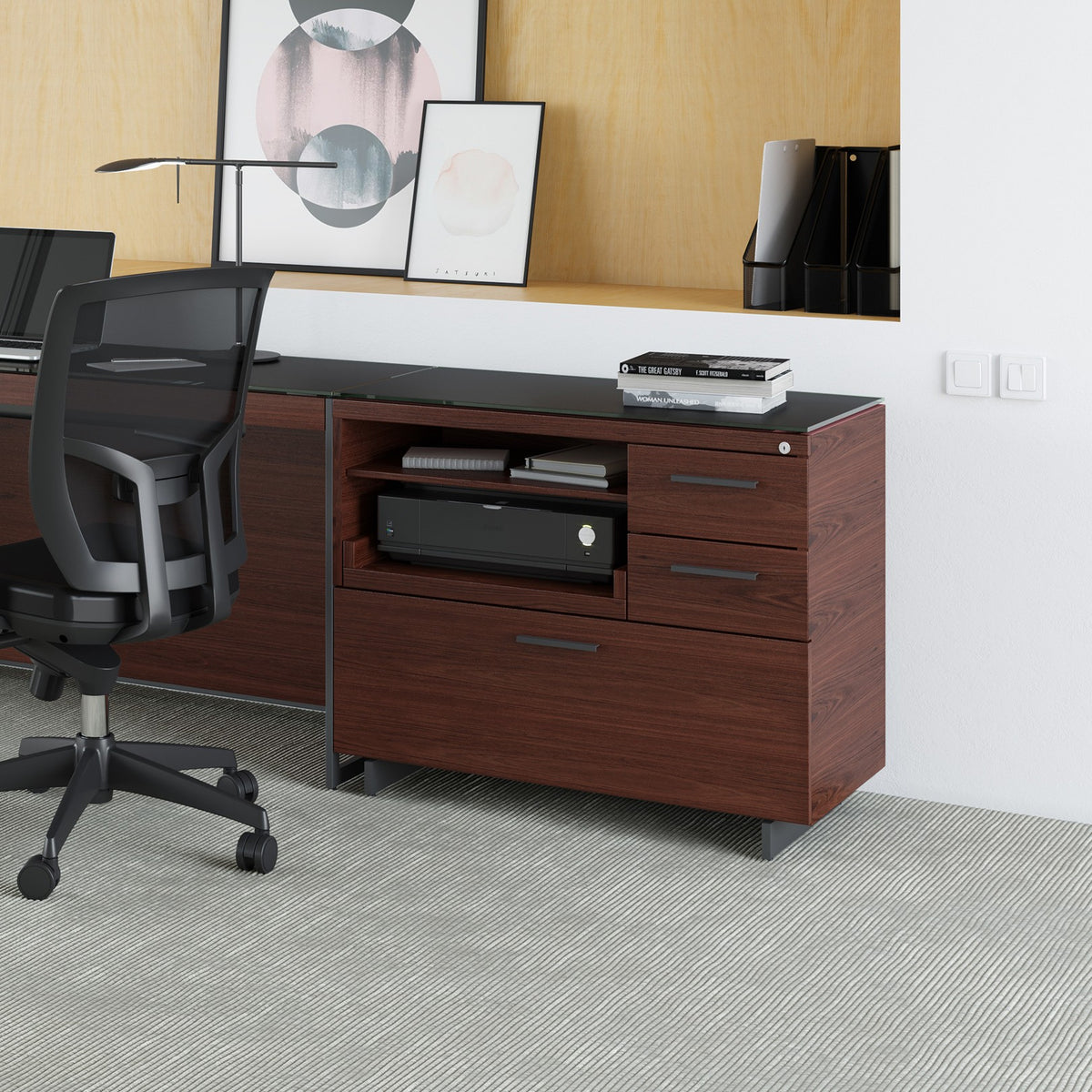BDi Sequel 20 6117 Multi Function Cabinet in Chocolate Stained Walnut, with a black base, beside a lateral file under a desk top, in an office