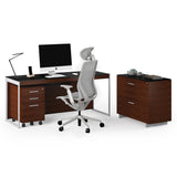BDi Sequel 20 6107 Mobile File Cabinet in Chocolate Stained Walnut, under a desk beside a lateral file, on white