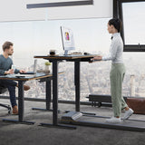BDi Sequel 20 Sit + Stand Desk in Natural Walnut, two desks, one raised, with people working, in an office