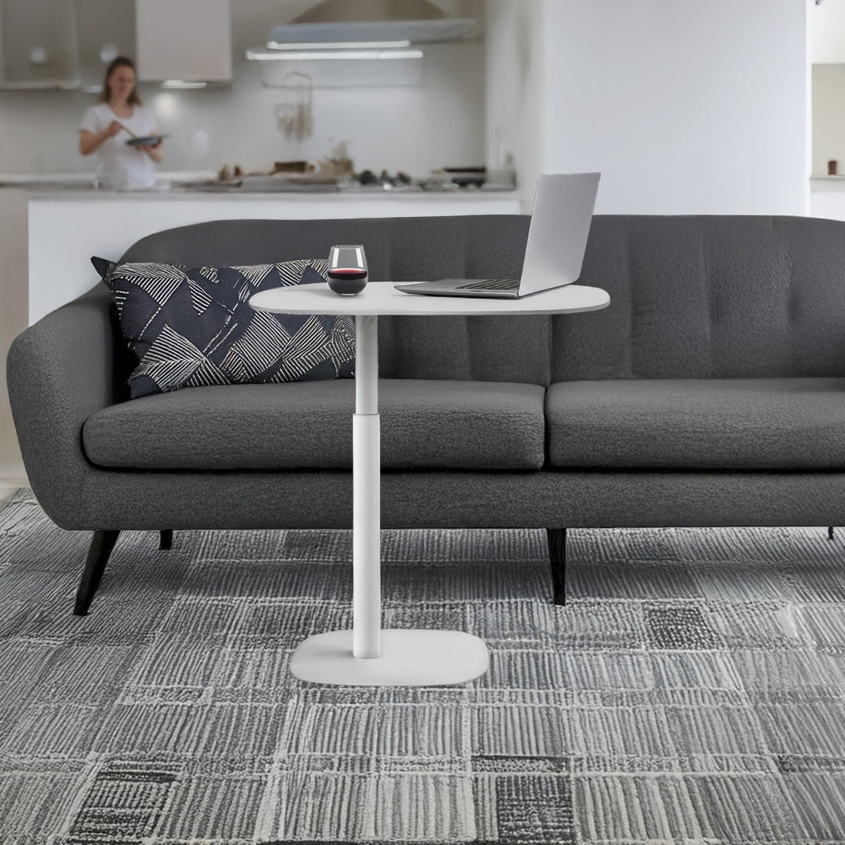 BDi Serif 1045 Adjustable Side/Laptop Table in Salt | Metal, beside a sofa with a laptop