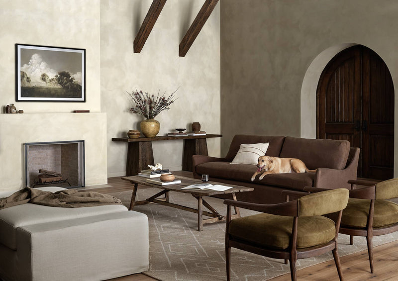 Four Hands living room with a brown sofa, olive leather chairs and a wood coffee table
