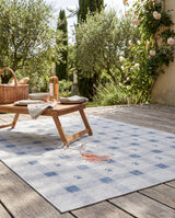 Dash & Albert Gingham Machine Washable Rug in Blue, patio setting